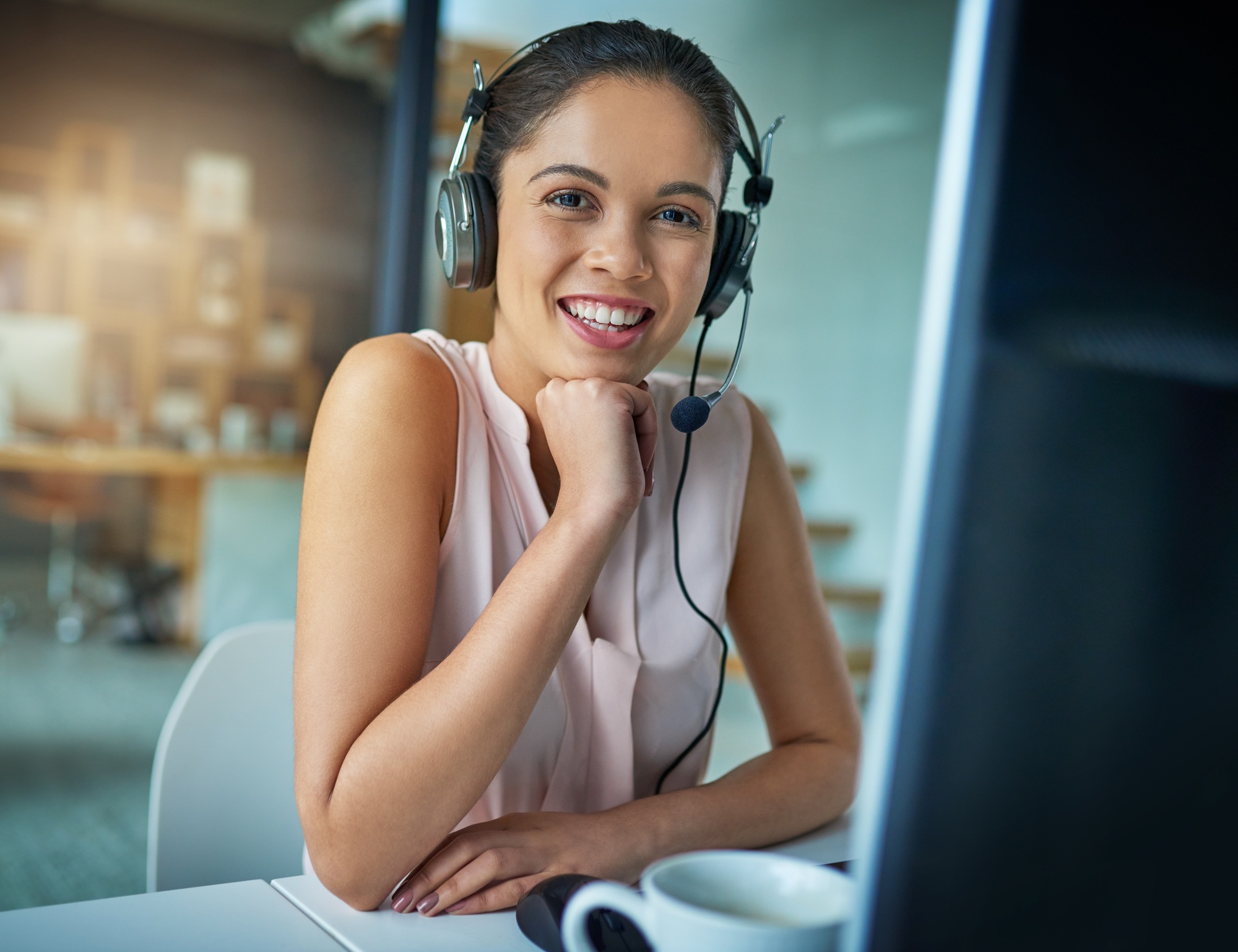 Here to help you with your queries. Shot of a young woman working in a call center.